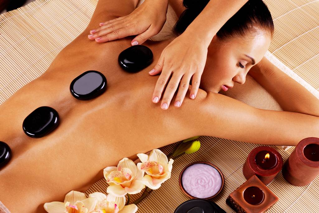 Adult woman having hot stone massage in spa salon Adult woman having hot stone massage in spa salon