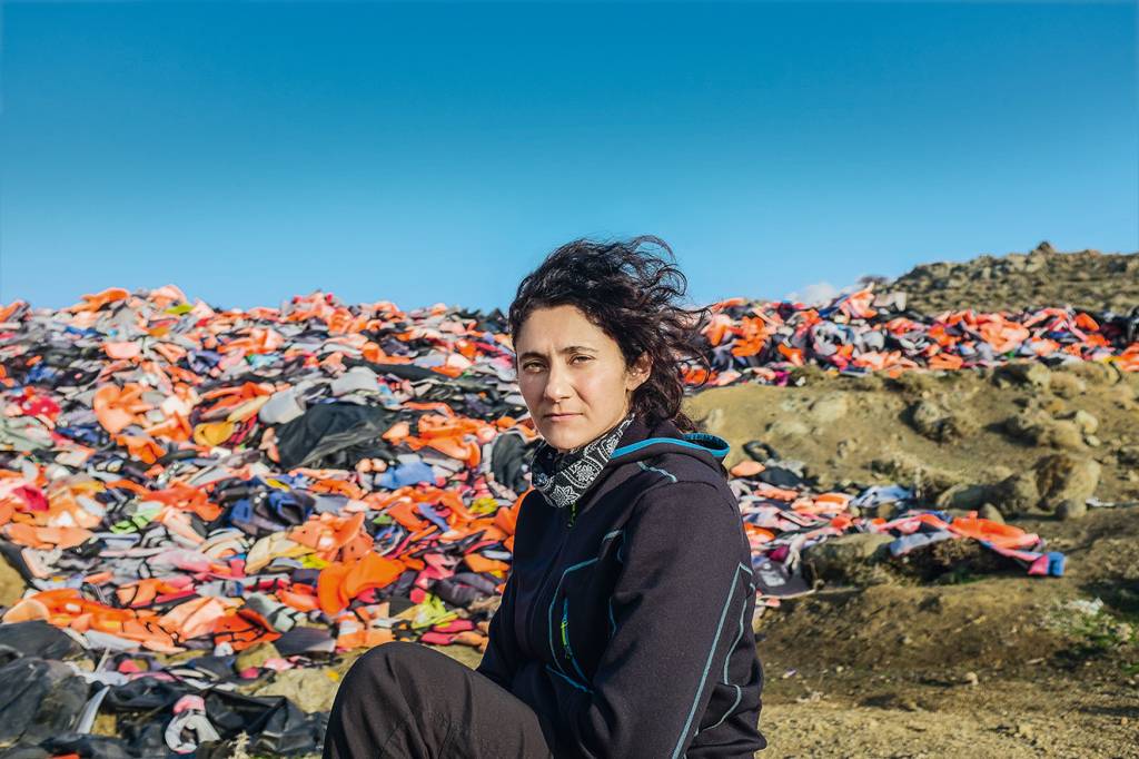 Isabel, 38 years old, from Mexico, head of the recycling and upcycling project of the Swedish NGO Lighthouse Relief called ECO Relief. Here photographed inside the surreal and touching life jackets cemetery created near Molyvos, in the north-west of Lesbo