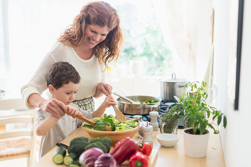 USA, New Jersey, Jersey City, Mother and son (6-7) cooking together panelas