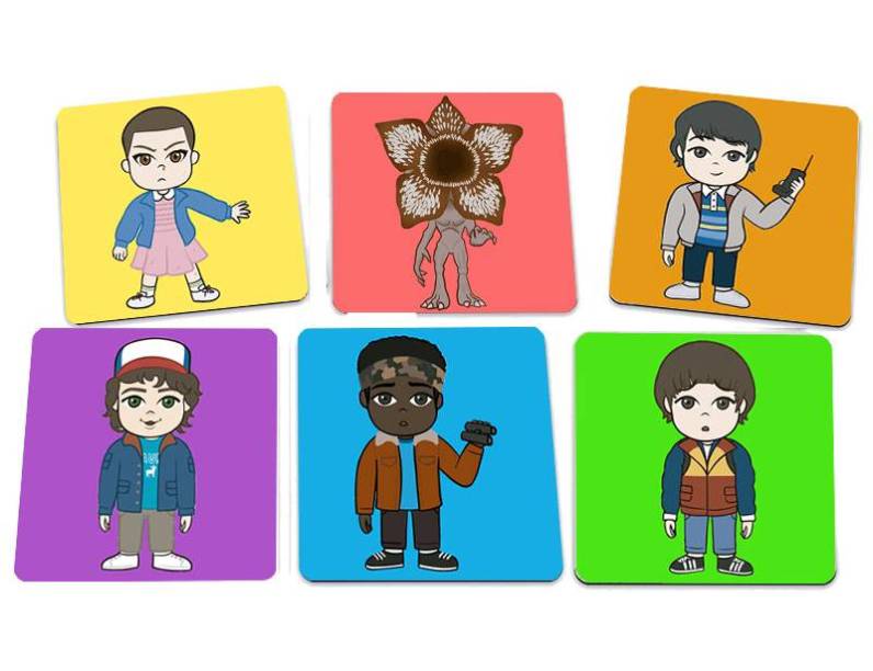 Porta-copos Personagens, de PET, 9 x 9 cm cada. <a href="https://www.geekhoard.com.br/jogo-de-porta-copos-stranger-things-personagens?rhWid=8843&utmi_source=roihero&utmi_medium=roihero&utmi_content=roihero" target="_blank" rel="noopener">Geek Hoard</a>, R$ 26,75