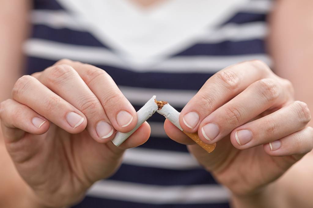 Woman breaking cigarette. She trying to quit smoking