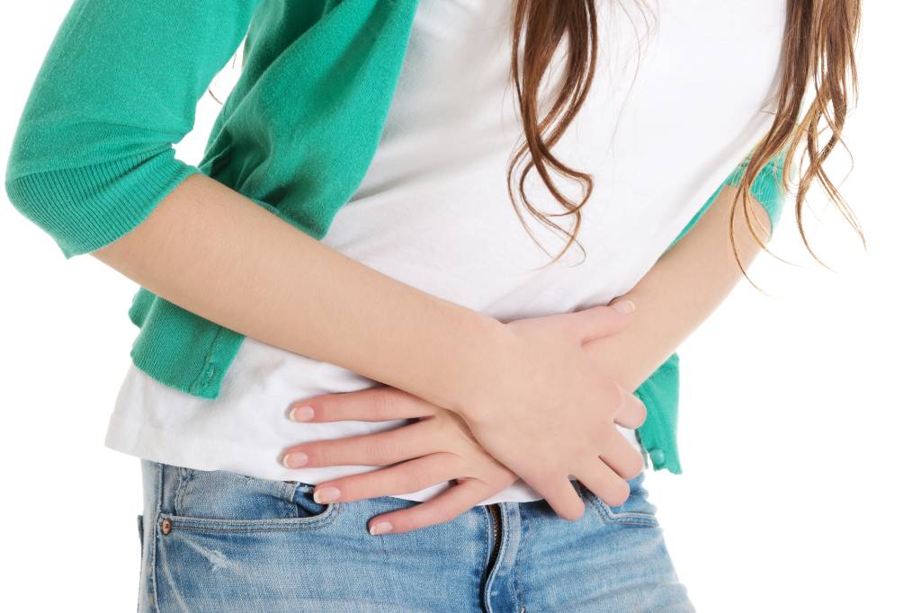 Torso of woman with hands placed on aching stomach