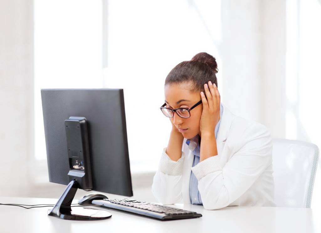 Stressed African woman at work with hands covering her ears