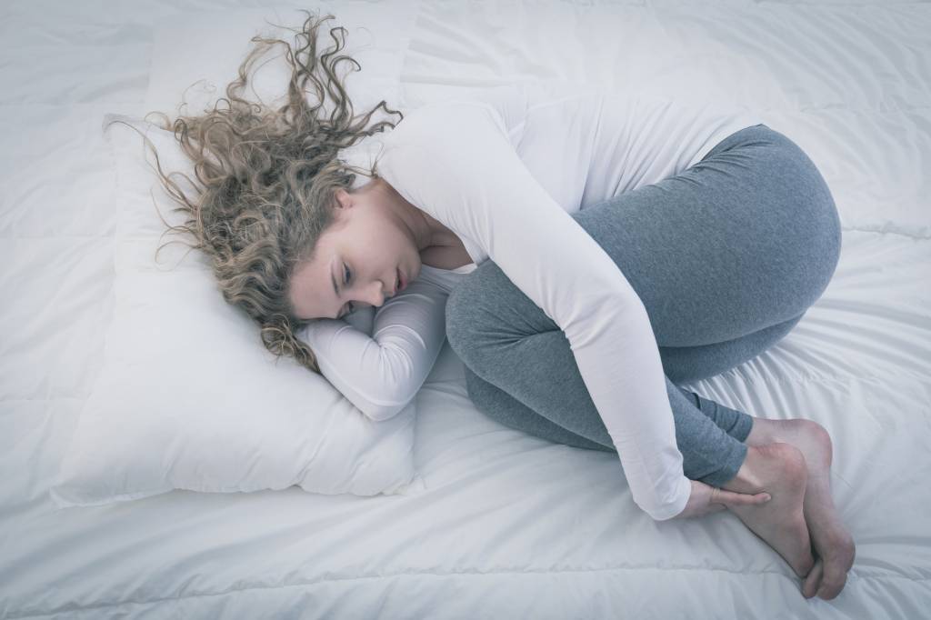 Woman curled up in bed