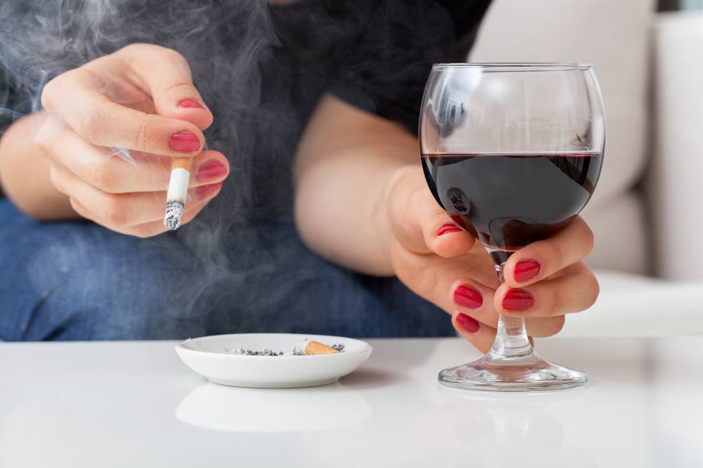 Erros que prejudicam a pele Fumar e beber Woman with addictions