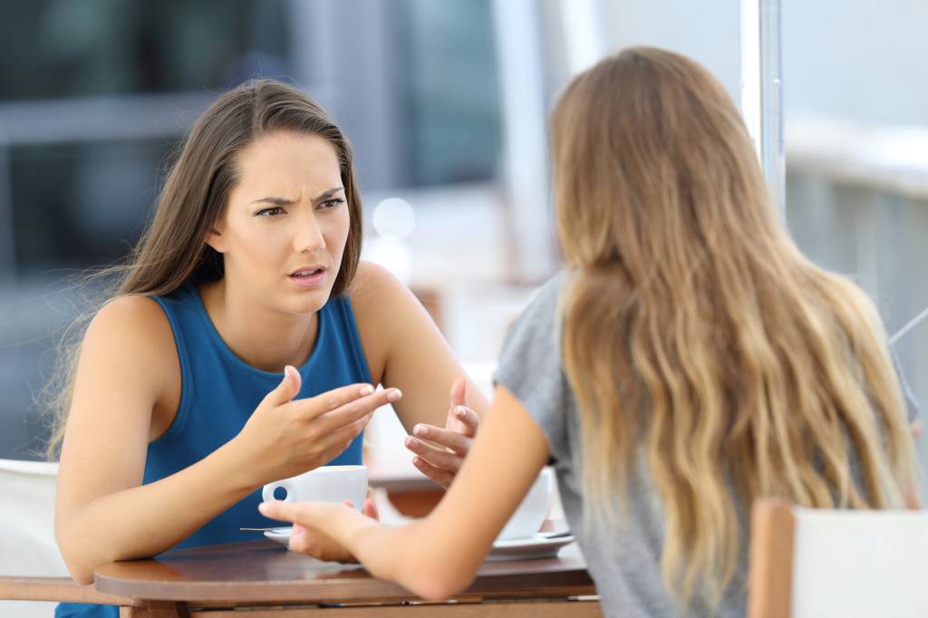 Two girls talking seriously in a coffee shop