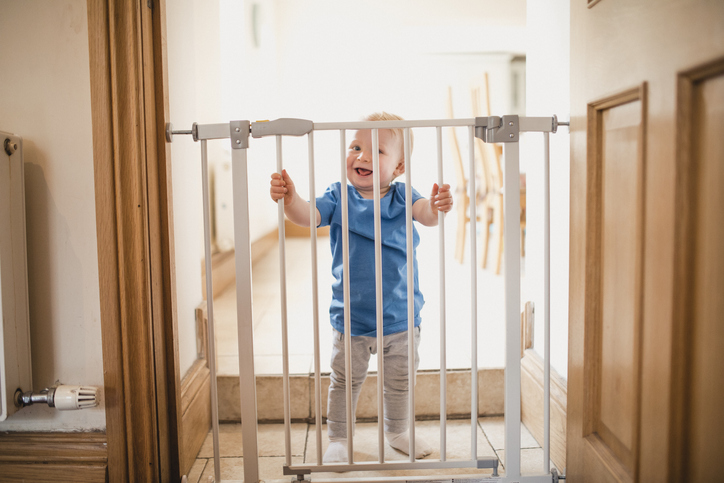 Bebê segurando grade de proteção