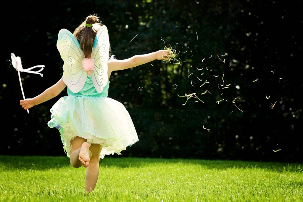 A girl in fairy costume running and thowing grass A girl in fairy costume running and thowing grass