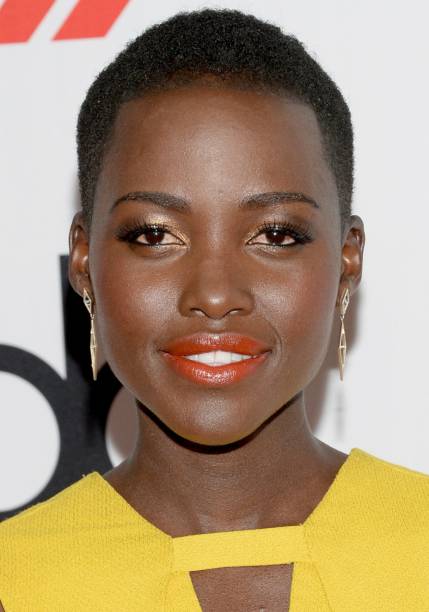 <strong>Lupita Nyong'o:</strong> acompanhado de sombra dourada, cílios definidos e uma cútis superiluminada, o batom laranja suave cria um visual poderoso.