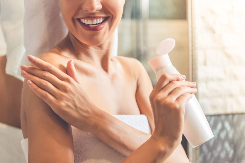 Mulher aplicando creme hidratante