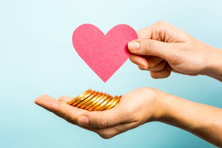 Golden coins, red heart paper shape. Love and money concept