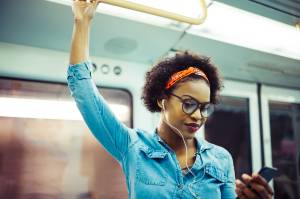 Mulher ouvindo música no metrô Mulher ouvindo música no metrô