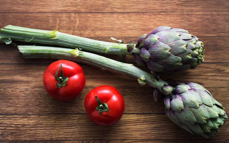tomatoes and artichokes on the wooden background, horizontal, healthy food, vegetables