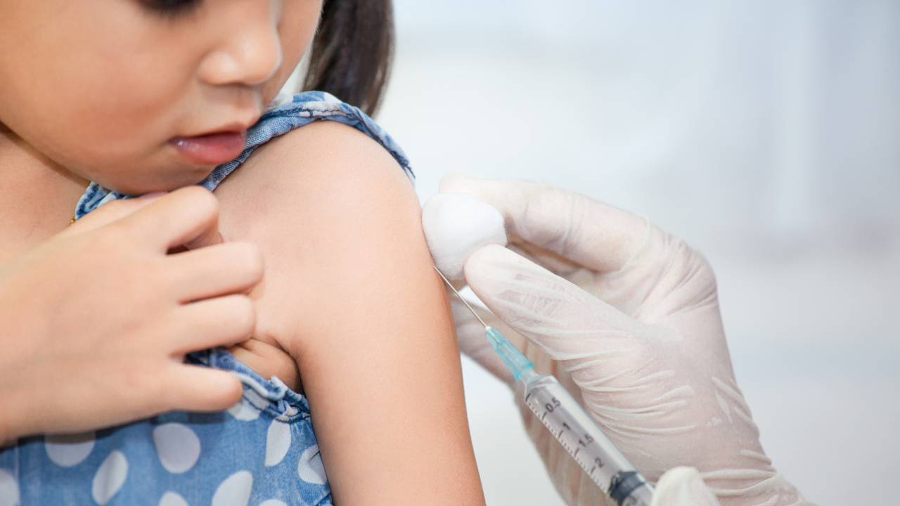Doctor injecting vaccination in arm of asian little child girl,healthy and medical concept