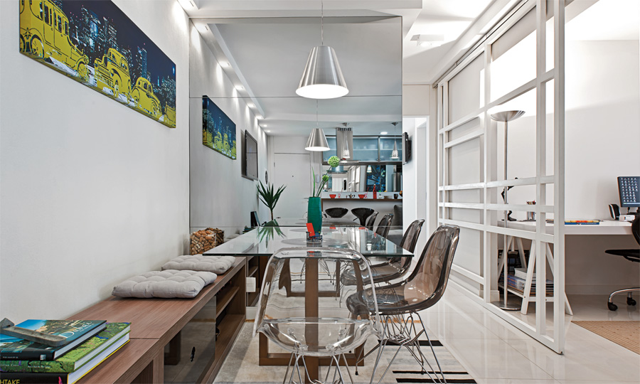 O espelho dá sensação de profundidade e amplia o espaço. Para não pesar no ambiente, o morador escolheu uma mesa com tampo de vidro e base de madeira em cruz. Seguindo a proposta de leveza, as cadeiras são de acrílico incolor e preto. Projeto de Daniel Tesser. O espelho dá sensação de profundidade e amplia o espaço. Para não pesar no ambiente, o morador escolheu uma mesa com tampo de vidro e base de madeira em cruz. Seguindo a proposta de leveza, as cadeiras são de acrílico incolor e preto. Projeto de Daniel Tesser.