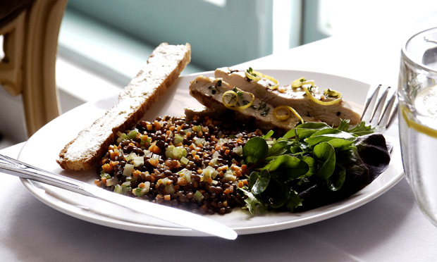 receita-salada-de-lentilhas-frango-grelhado Sobre um prato branco está a salada de lentilha com pedaços de frango e folhas verdes