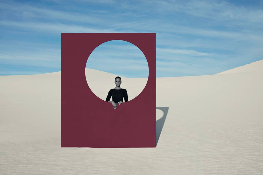 Portrait of young woman looking through window frame at white desert Portrait of young woman looking through window frame at white desert