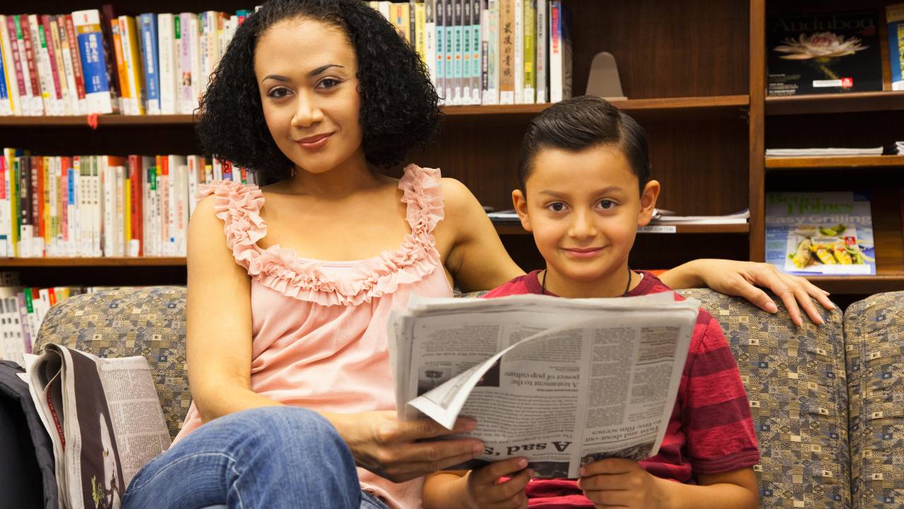 mãe e filho lendo jornal