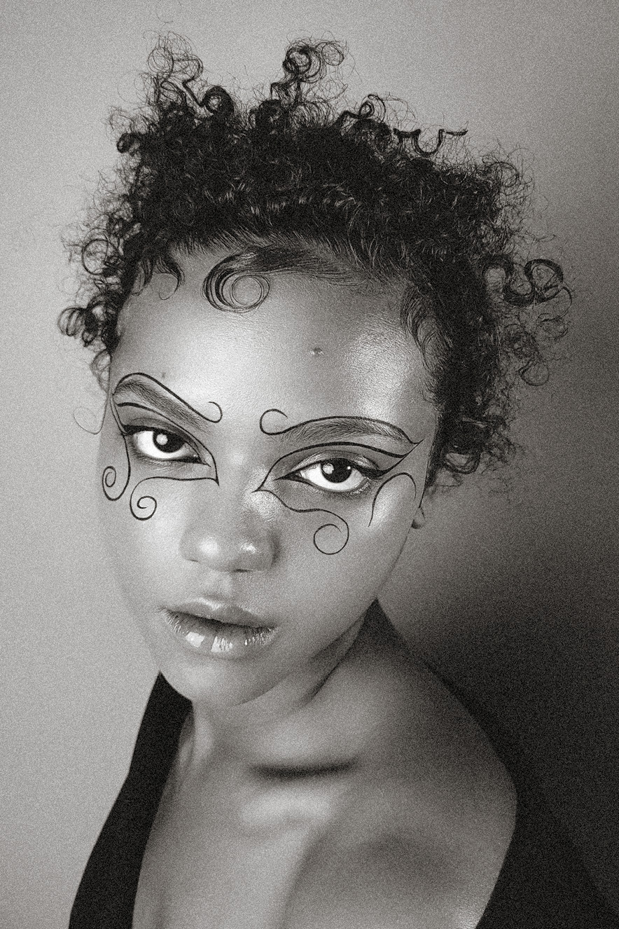 Mulher negra olha para a c&acirc;mera. Ela tem no olho um desenho feito com delineador