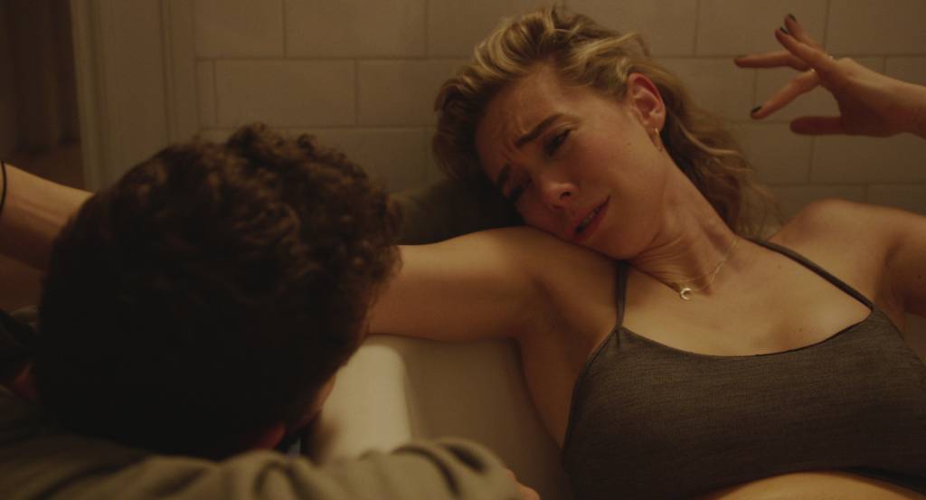 PIECES OF A WOMAN: (L to R) Shia LeBeouf as Sean and Vanessa Kirby as Martha Uma mulher loira está deitada dentro de uma banheira, olhando para um homem, do lado de fora