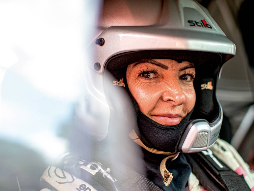 claudia-grandi-rally-dos-sertoes Mulher branca olha para a foto. Ela está usando um capacete
