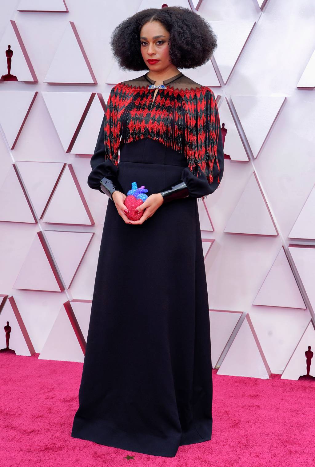 93rd Annual Academy Awards – Arrivals Celeste é uma mulher negra com cabelos castanhos cacheados. Ela usa um vestido bordado com pedraria em todo o tronco e saia preta. Em suas mãos, carrega uma clutch em formato de coração
