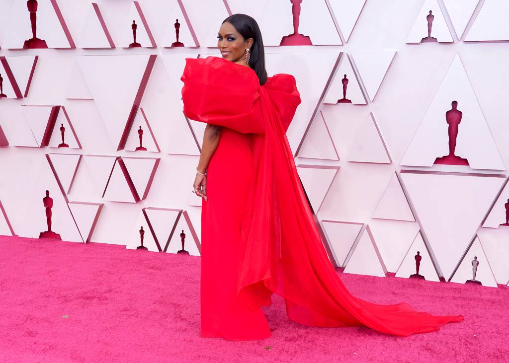 93rd Annual Academy Awards – Arrivals Angela é uma mulher negra com cabelos castanhos lisos e longos. Ela usa um vestido vermelho com laço enorme nas costas