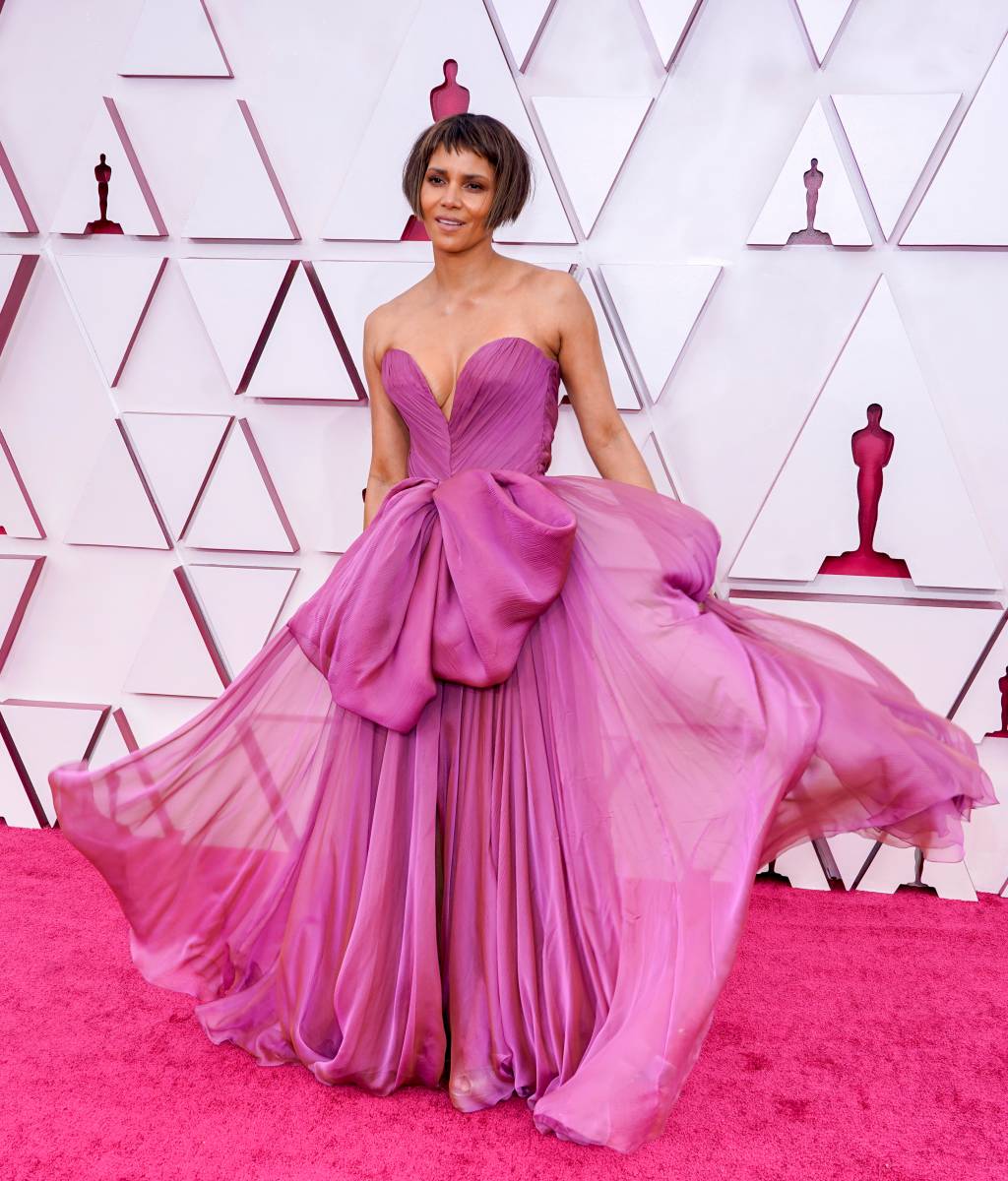 93rd Annual Academy Awards – Arrivals Halle é uma mulher negra com cabelos castanho e mechas costados na altura da orelha e com franja no meio da testa. Ela usa um vestido lilás fluido com laço na frente