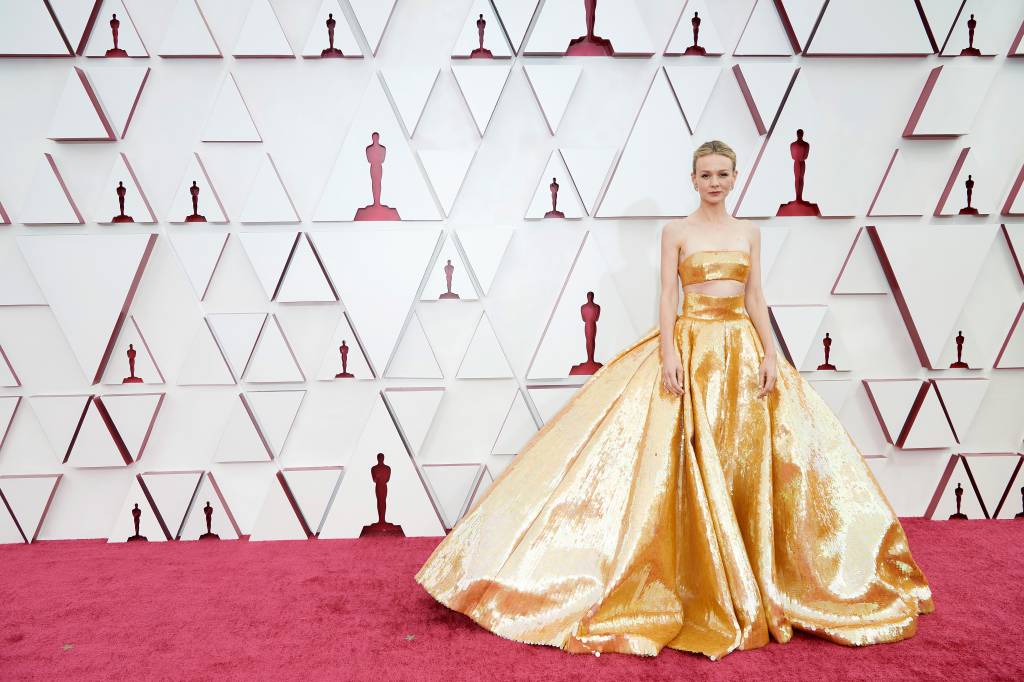 93rd Annual Academy Awards – Arrivals Carey é uma mulher branca, loira, com um vestido de saia volumosa dourado e recorte logo abaixo dos seios