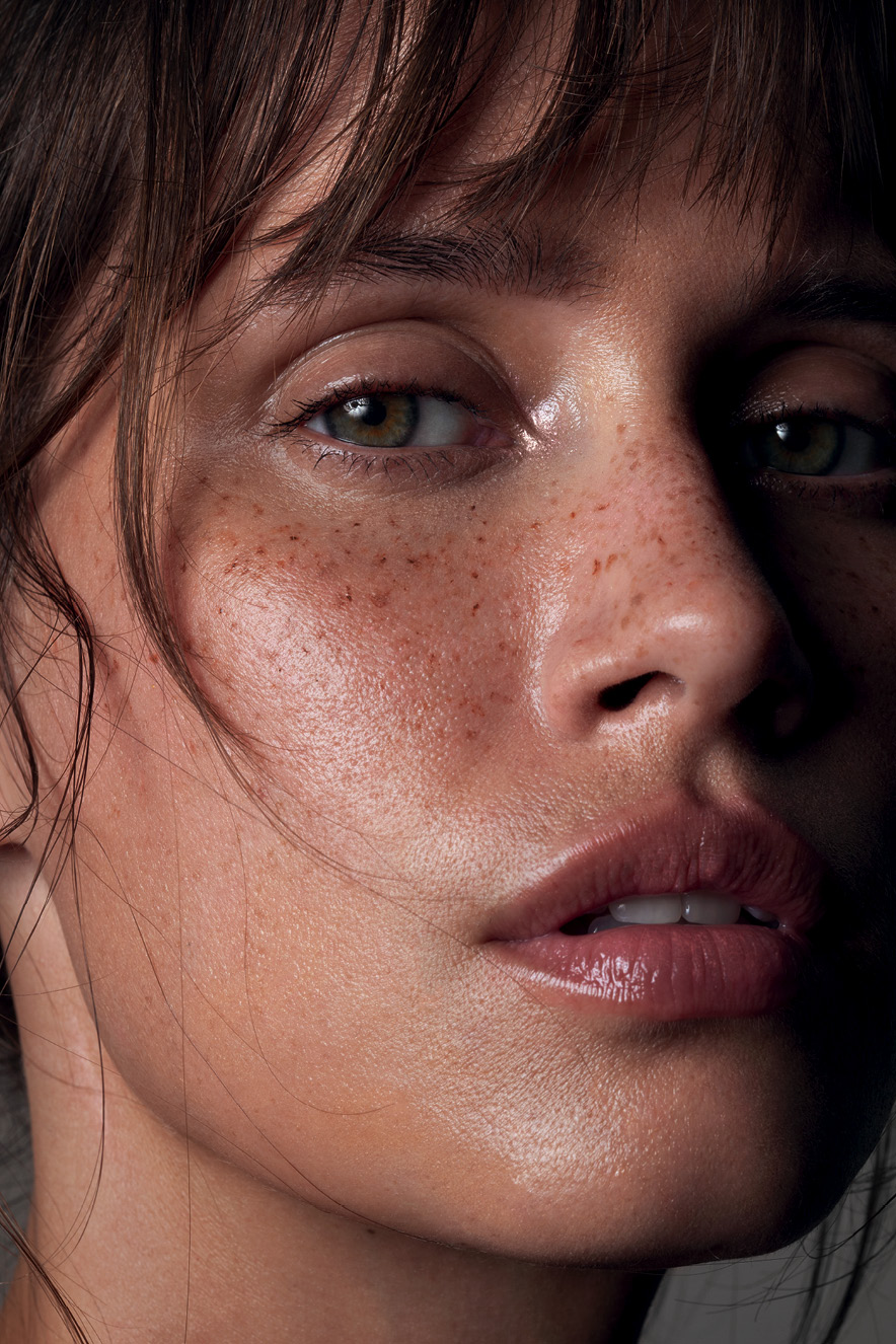 Em retrato, mulher maquiada com pele natural olha para a c&acirc;mera