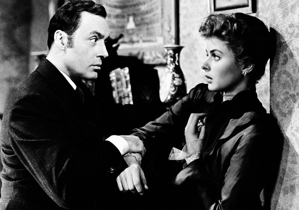 Cena do filme Gaslight, em que um homem prende os braços de mulher.