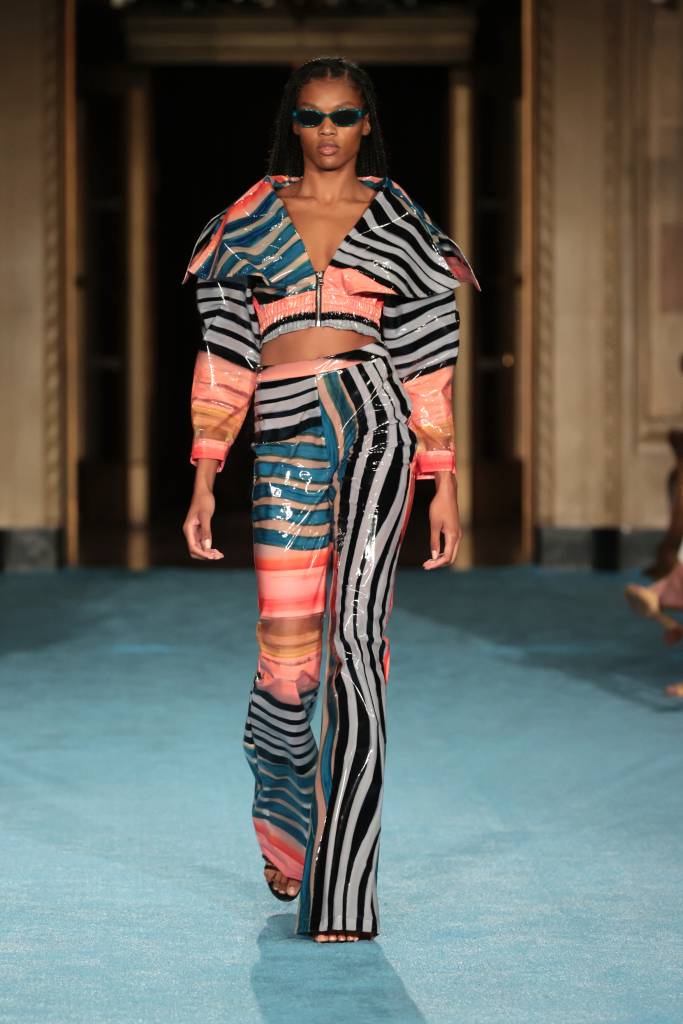 Christian Siriano SS2022 NYFW Show – Runway Modelo com calça e casaco colorido na passarela.