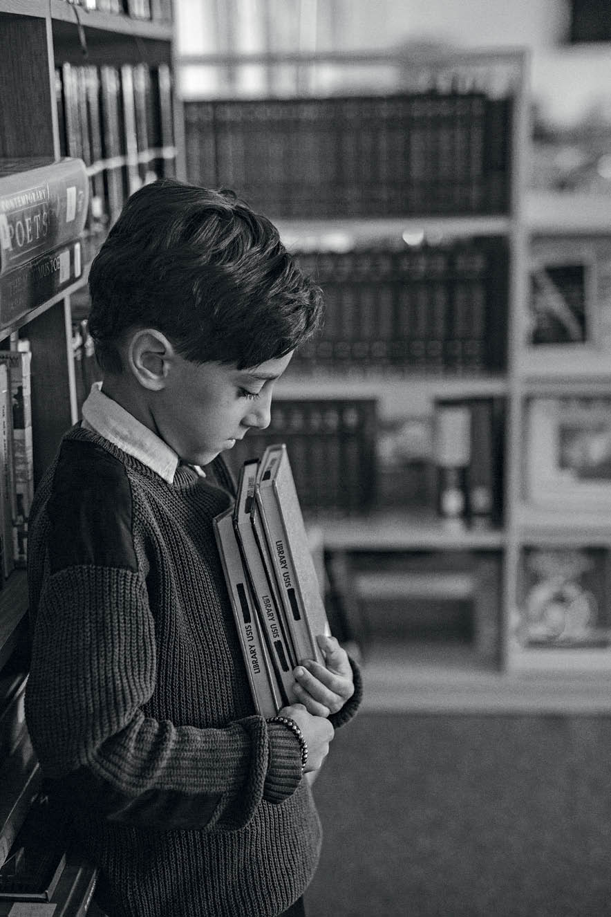 VOLTA AS AULAS2 menino, com a cabeça abaixada, segurando livros