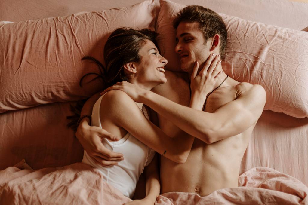 Happy young couple lying in bed Sexo sem roteiro