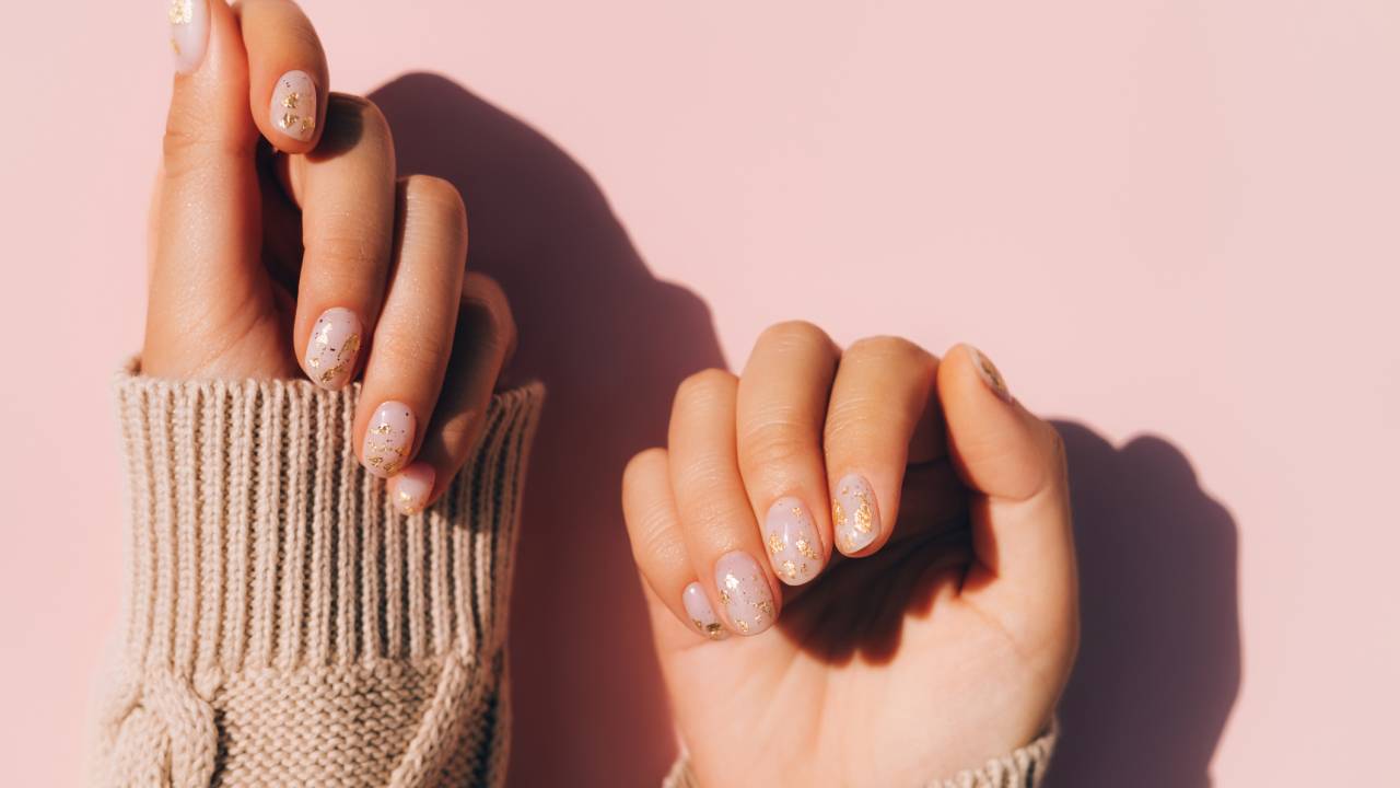 Unhas esmaltadas em fundo rosa