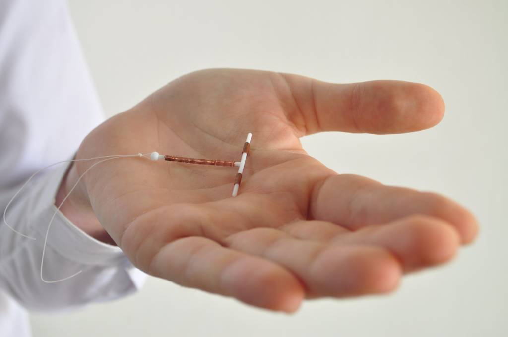 Holding an IUD birth control device in hand Holding an IUD birth control device in hand