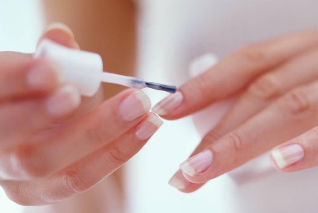 Young woman painting fingernails, close-up Mulher pintando a unha