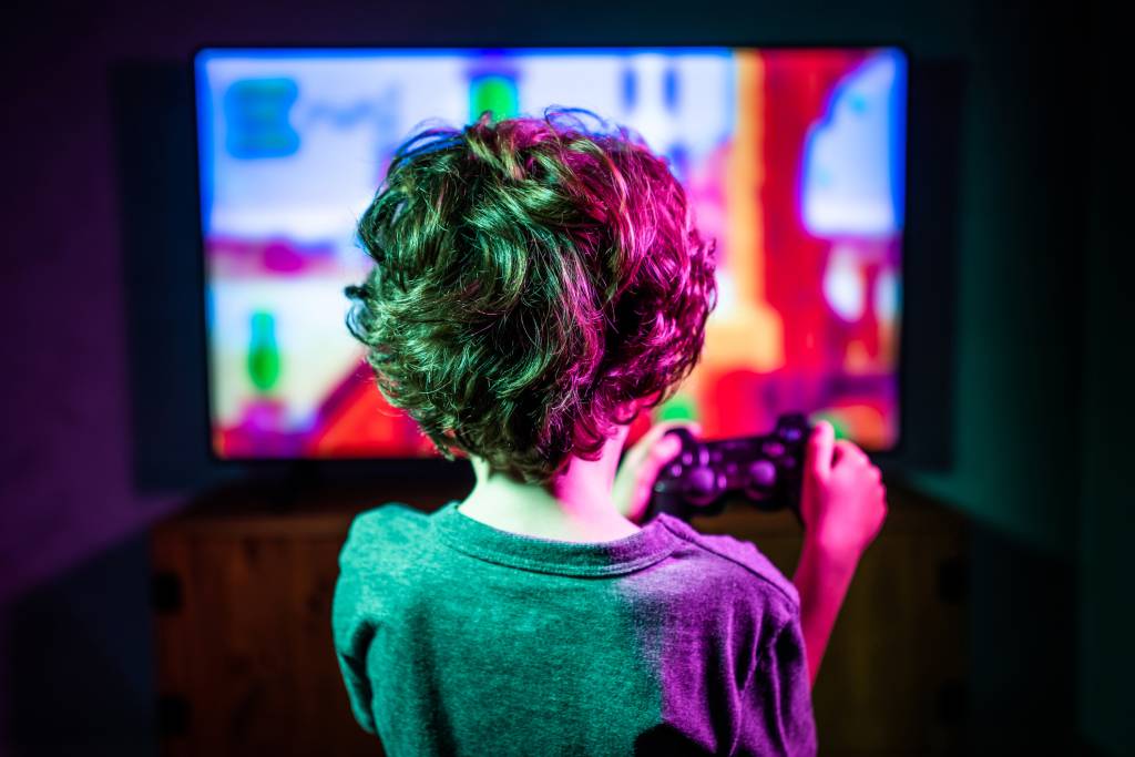 Little boy playing video game Jogos digitais
