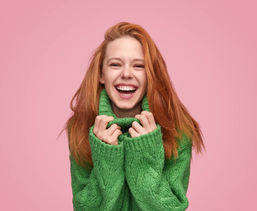 Bright laughing teenage girl on pink background Beleza pessoal