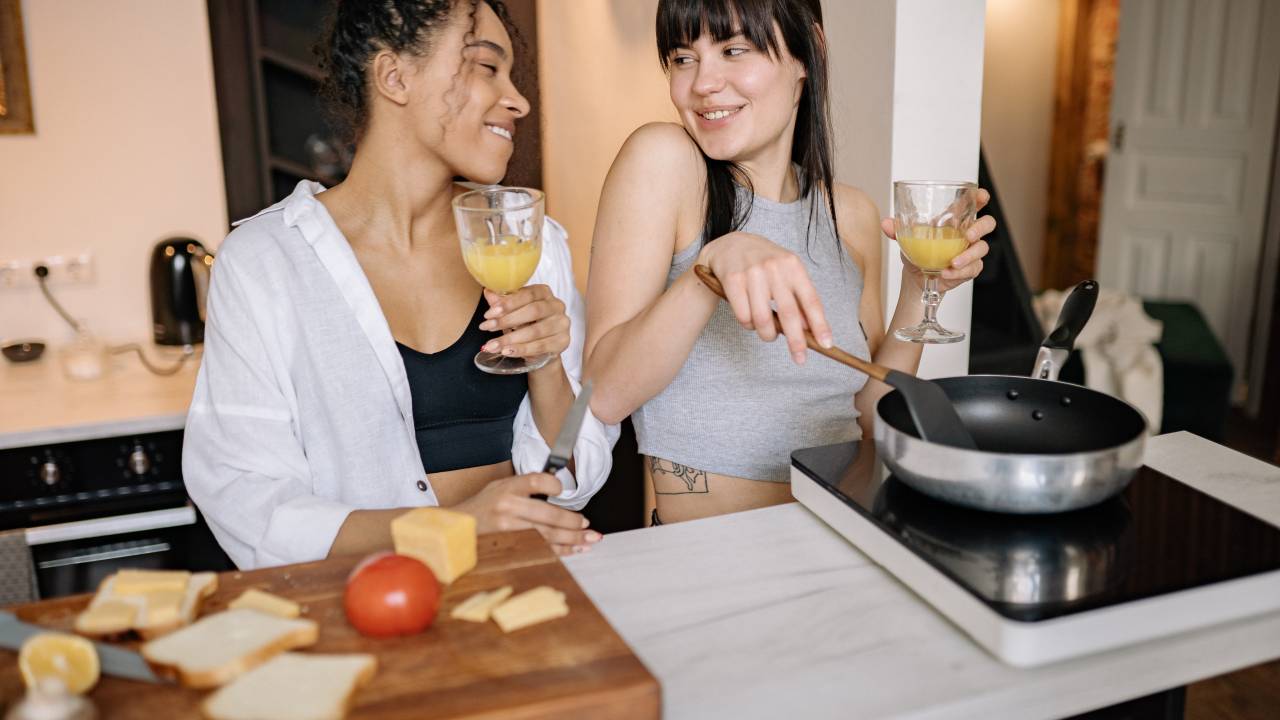 Um casal de mulheres cozinha juntas.