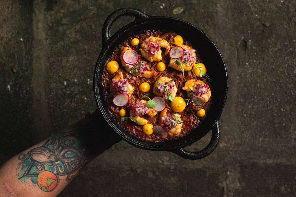 A sopa seca é feita de fideuá cremoso camarões, lascas de panceta, leve crosta por baixo, chalaquita e alioli de pimenta amarela A sopa seca é feita de fideuá cremoso camarões, lascas de panceta, leve crosta por baixo, chalaquita e alioli de pimenta amarela
