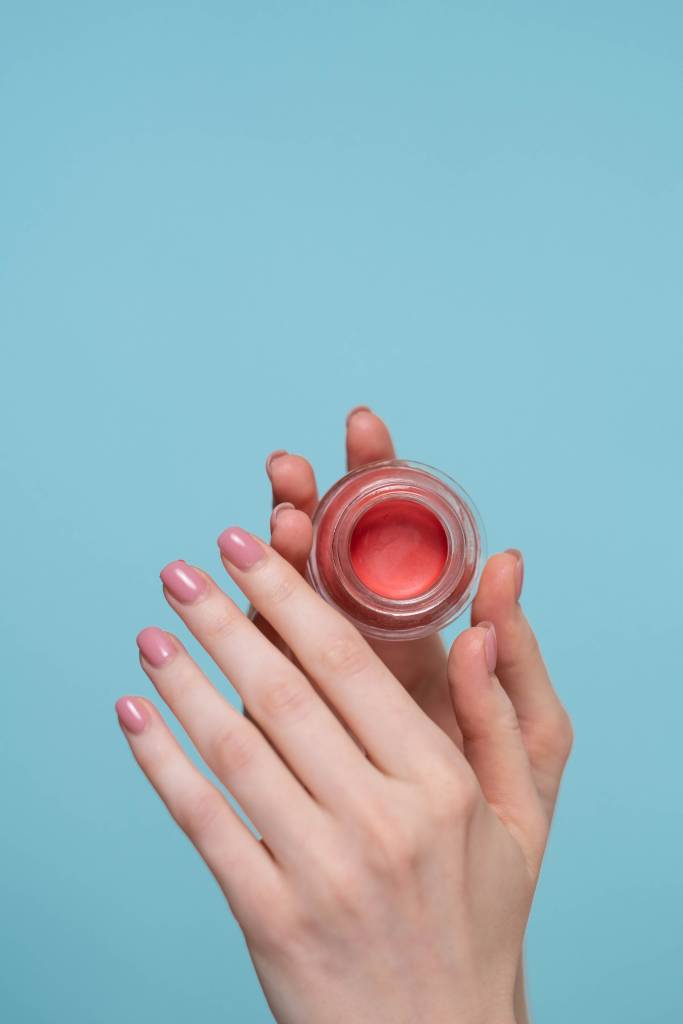 hidratar-mãos-parar-de-roer-unhas-fortes Mãos segurando um hidratnte de cutículas
