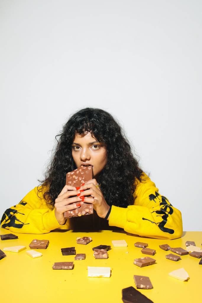 alimentos-ultraprocessados-girl-dinner Mulher comendo várias barras de chocolate