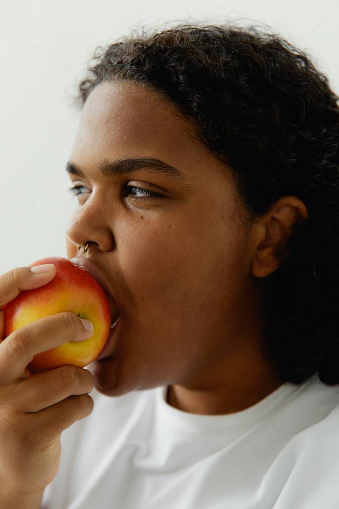 Mulher comendo uma maçã