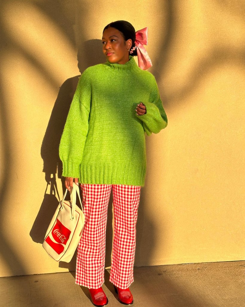 Mix de cores de sucesso com o sueter oversized verde, calça de vichy vermelha laço rosa de cetim