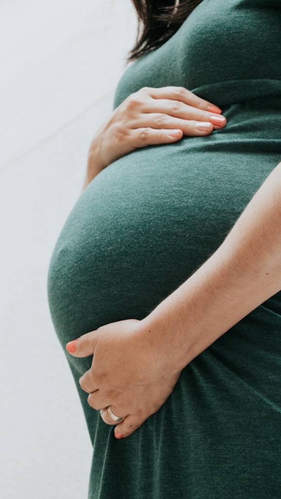 Mulher grávida segurando a sua barriga