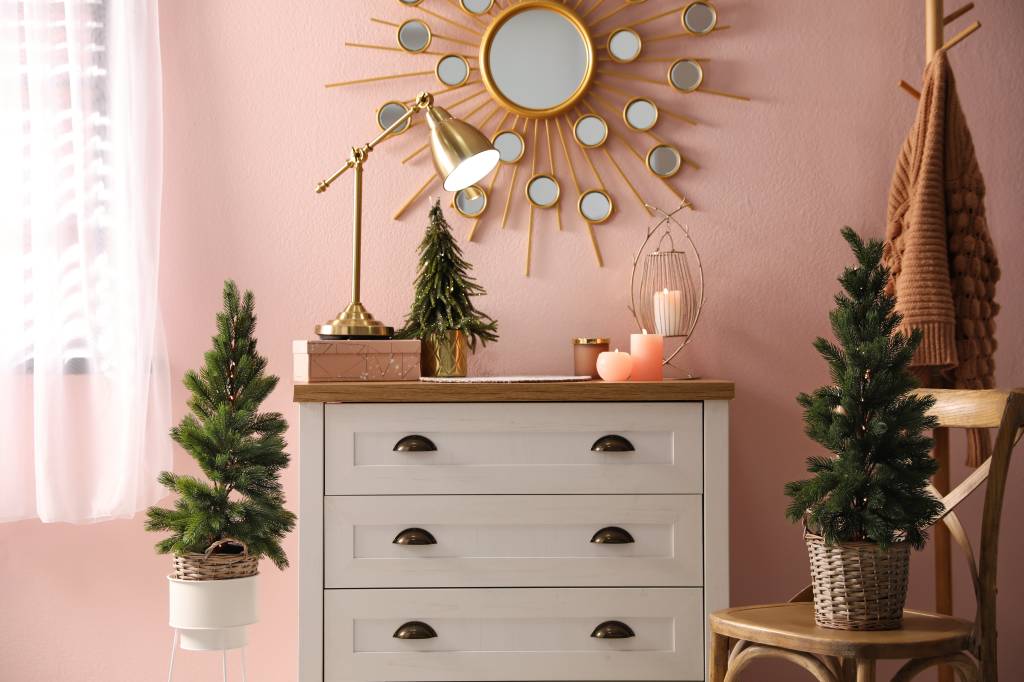 Stylish room interior with dresser and small fir trees Stylish room interior with dresser and small fir trees