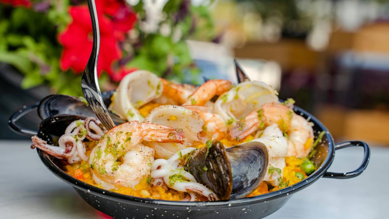 Panelinha com arroz e frutos do mar, como camarão e vôngole