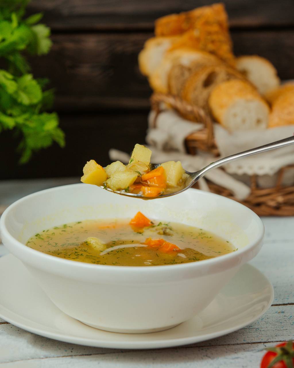 close up of spoon with chicken soup with vegetables and dill Receita de sopa de legumes cremosa com pão crocante
