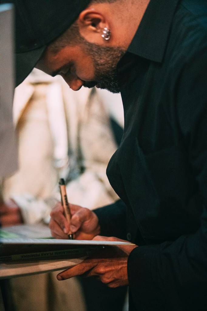 Vitorino Campos fazendo dedicatória para quem recebesse seu livro autografado